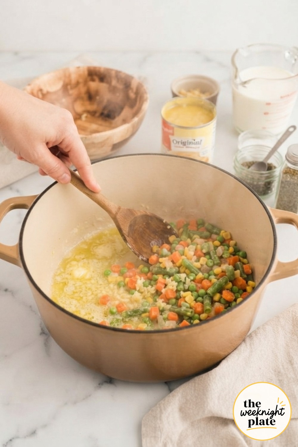 Sautéing diced vegetables and garlic in butter, the first step in building chicken pot pie soup from scratch